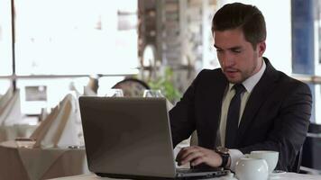 homem usando computador portátil às hora do almoço às uma cafeteria video