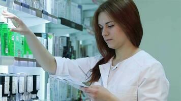jovem fêmea farmacêutico selecionando uma medicação video