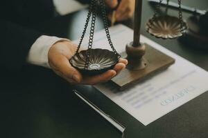 Business and lawyers discussing contract papers with brass scale on desk in office. Law, legal services, advice, justice and law concept picture with film grain effect photo