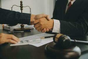 Business and lawyers discussing contract papers with brass scale on desk in office. Law, legal services, advice, justice and law concept picture with film grain effect photo