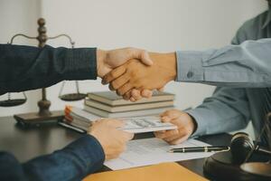 Business and lawyers discussing contract papers with brass scale on desk in office. Law, legal services, advice, justice and law concept picture with film grain effect photo