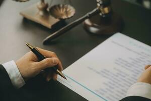 Business and lawyers discussing contract papers with brass scale on desk in office. Law, legal services, advice, justice and law concept picture with film grain effect photo