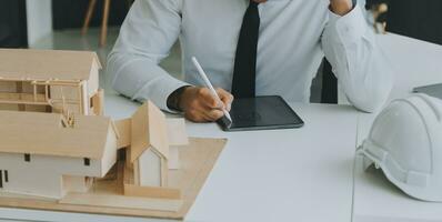 Construction and structure concept of Engineer or architect meeting for project working with partner and engineering tools on model building and blueprint in working site, contract for both companies. photo