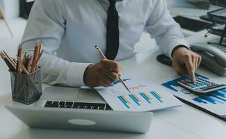 Close up of Business team analyzing income charts and graphs with modern laptop computer. Business analysis and strategy concept. photo