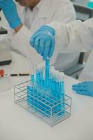 Health care researchers working in life science laboratory. Young female research scientist and senior male supervisor preparing and analyzing microscope slides in research lab. photo