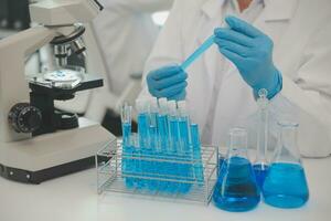 Health care researchers working in life science laboratory. Young female research scientist and senior male supervisor preparing and analyzing microscope slides in research lab. photo