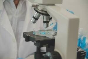 Health care researchers working in life science laboratory. Young female research scientist and senior male supervisor preparing and analyzing microscope slides in research lab. photo