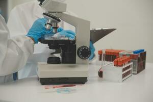Health care researchers working in life science laboratory. Young female research scientist and senior male supervisor preparing and analyzing microscope slides in research lab. photo