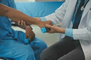 Physiotherapist man giving exercise with dumbbell treatment About Arm and Shoulder of athlete male patient Physical therapy concept photo