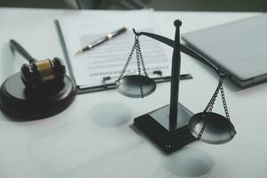 Business and lawyers discussing contract papers with brass scale on desk in office. Law, legal services, advice, justice and law concept picture with film grain effect photo