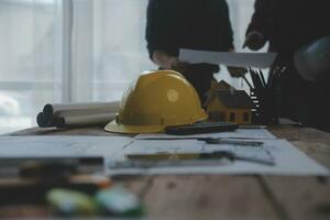 Close up of civil male engineer asian working on blueprint architectural project at construction site at desk in office. photo