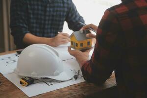 Close up of civil male engineer asian working on blueprint architectural project at construction site at desk in office. photo