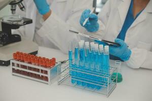 Health care researchers working in life science laboratory. Young female research scientist and senior male supervisor preparing and analyzing microscope slides in research lab. photo