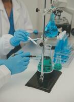 Health care researchers working in life science laboratory. Young female research scientist and senior male supervisor preparing and analyzing microscope slides in research lab. photo