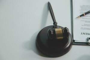 Business and lawyers discussing contract papers with brass scale on desk in office. Law, legal services, advice, justice and law concept picture with film grain effect photo