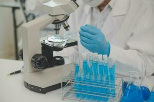 Health care researchers working in life science laboratory. Young female research scientist and senior male supervisor preparing and analyzing microscope slides in research lab. photo