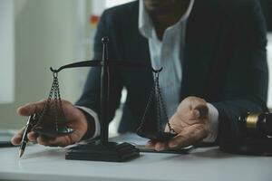 Business and lawyers discussing contract papers with brass scale on desk in office. Law, legal services, advice, justice and law concept picture with film grain effect photo