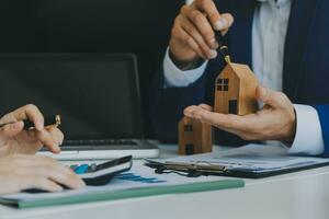 Female woman hands holding home model, small miniature white toy house. Mortgage property insurance dream moving home and real estate concept photo