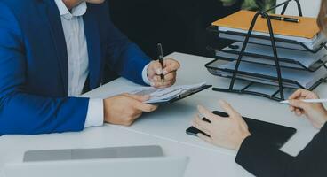 empresario empresario asiático y mujer de negocios discutiendo un nuevo proyecto de negocios en tableta en una reunión moderna en una oficina moderna, concepto casual de negocios asiáticos. foto