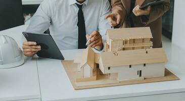 Construction and structure concept of Engineer or architect meeting for project working with partner and engineering tools on model building and blueprint in working site, contract for both companies. photo