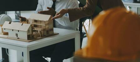 Construction and structure concept of Engineer or architect meeting for project working with partner and engineering tools on model building and blueprint in working site, contract for both companies. photo