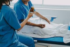 Women Asian doctors hold the patient hand and encourage and provide medical advice While checking the patient health in bed. Concept of Care and compassion, antenatal care, Threatened abortion photo