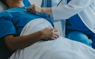 Women Asian doctors hold the patient hand and encourage and provide medical advice While checking the patient health in bed. Concept of Care and compassion, antenatal care, Threatened abortion photo