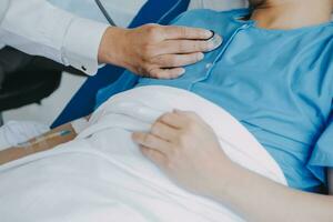 Women Asian doctors hold the patient hand and encourage and provide medical advice While checking the patient health in bed. Concept of Care and compassion, antenatal care, Threatened abortion photo