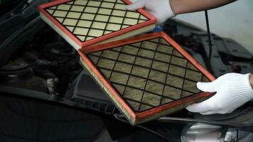 mechanic holds a new car air filter to replace the old car filter,Replacing a new air filter in a passenger car video