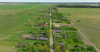 panoramic aerial view and flight over eco village with wooden houses, gravel road, gardens and orchards video