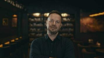 Portrait of an adult man in a dark and stylish bar or restaurant. The owner of the establishment and business is in the picture. video