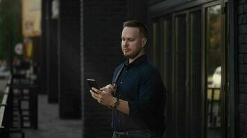 Modern urban man uses a smartphone on a city street. Internet technologies make it easier to access various services and assistants using mobile applications. video