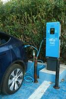 Istanbul, Turkey - November 5, 2023, Dark blue Tesla Model Y is charging at outdoor in a charging station known as Esarj in Turkey photo