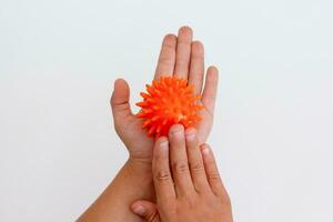 Cropped child hands doing exercise using spiky ball photo