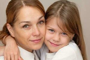 Portrait of mother and daughter hugging photo