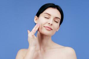 Close up of woman body care at home. Portrait of woman applying moisturizer cream on neck. Natural skin care photo