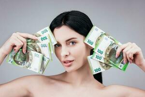 Business, finance and investment concept. Beautiful and sexy woman looking impressed is holding euro cash. Beauty and banking concept photo