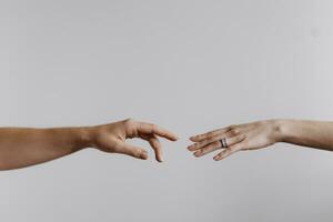 Fingers of Two People Nearly Touching. Beautiful man's and woman's hands touching each other isolated on grey background. Close up help hand. Helping hand concept, support. Friendly handshake. photo