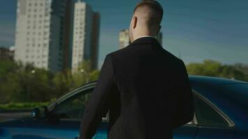 uma bem sucedido e elegante homem de negocios vai para pegue para dentro dele carro. caloroso outono tarde dentro a cidade. video