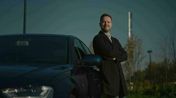 Portrait of an elegant looking man next to his premium car. A successful entrepreneur or manager is standing near a car. video