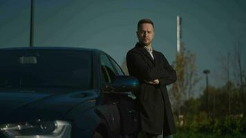 Portrait of an elegant looking man next to his premium car. A successful entrepreneur or manager is standing near a car. video