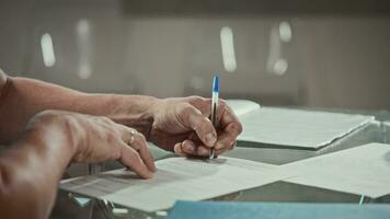 A male worker fills out an application form for employment at an enterprise. A female manager helps a new applicant fill out paperwork. video