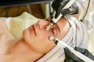 The cosmetologist makes the procedure ultrasonic face peeling photo