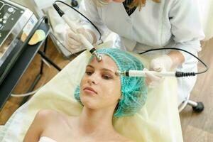 Cosmetologist makes the procedure microcurrent therapy beauty salon photo