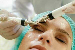 Cosmetologist makes the procedure microcurrent therapy beauty salon photo