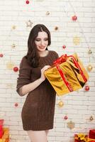 Beautiful curly brunette girl at the Christmas tree photo