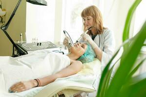 Cosmetologist makes the procedure microcurrent therapy beauty salon photo