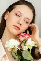 young beautiful woman smelling a bunch of red roses photo