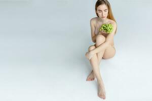 Woman holds grapes in the chest and hugs it with both hands. photo