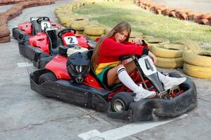 contento morena mujer ganando el karting carrera. foto